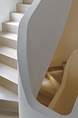 Winding staircase with wooden treads and stone railing