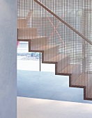 Contemporary staircase with metal grid dividing the staircase from the rest of the room