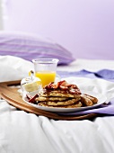 Frühstück im Bett (Orangensaft, Flapjacks mit Beeren, Würstchen)