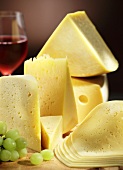 Various types of cheese with grapes and a glass of red wine