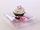 A cupcake with a pink ribbon