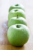 Four green, freshly washed apples