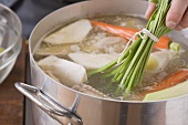 Putting soup vegetables into a pot