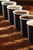 Kaffeebecher in einer Reihe stehend