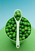 A bowl of peas and a plastic spoon