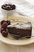 A slice of chocolate cake with cherries