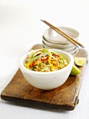 Rice dish with vegetables and pile of bowls