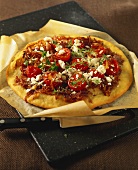 Pizza with onions, cherry tomatoes and feta on pizza tray