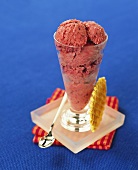 An ice cream sundae with blackberry ice cream and wafer