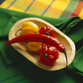 Eine rote Chili und Lampionchilis in einer Holzschale