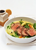 Saddle of lamb in pepper stock with vegetables
