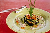Coloured pasta with tomato and cream sauce on green plate