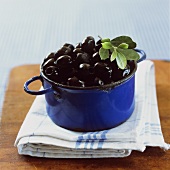 A blue pot with black olives