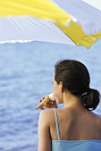 Young woman with ice cream cone on beach