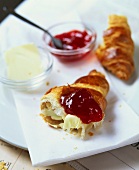 Croissant with butter and strawberry jam