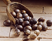 Nutmegs (Myristica fragrans) with wooden scoop