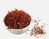 Saffron threads in and beside small bowl