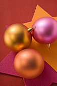 Three Christmas baubles (orange, gold and pink)