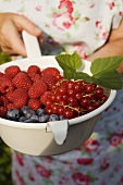Woman holding a strainer full of berries