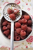 Fresh raspberries with sugar in a pan and on a skimmer