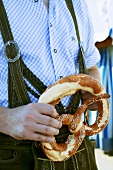 Man in national dress with pretzel (Oktoberfest, Munich)