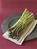 A bundle of green asparagus on linen cloth