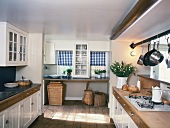 Rustic kitchen with white cupboards and gas cooker