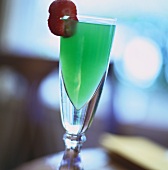 Green cocktail with strawberry on rim of glass