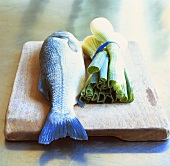 Sea bream and spring onions on wooden board
