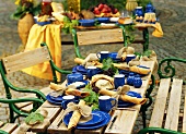 Wooden table laid with blue crockery in open air