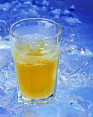 A glass of orangeade with ice cubes