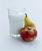 A glass of milk, an apple and a pear