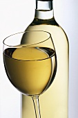 Glass of white wine in front of bottle
