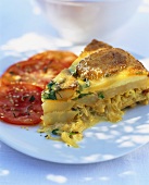 A piece of potato and onion tortilla with tomato slices