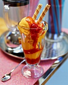 Mango sorbet and strawberry sauce in sundae glass