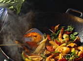 Sautéing shrimps and vegetables in wok