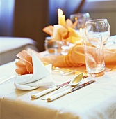 Place setting in white & salmon pink with glasses and candle