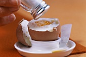 Sprinkling breakfast egg with salt