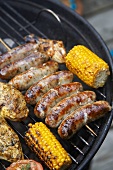 Sausages and corncobs on a barbecue
