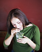 Young woman drinking Mojito through a straw