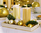 Porzellanschale mit Kerzen und Weihnachtskugeln