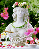Bust of woman with flower wreath on table in open air