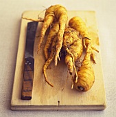 Parsnips with knife on a wooden board