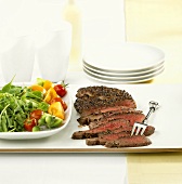Beef steak with pepper crust and salad