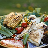 Grillteller mit Fladenbrot, Gemüse und Maiskolben