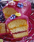 Filled Madeira cake with pink glacé icing