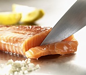 Cutting raw salmon fillet