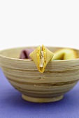 Fortune cookie on the edge of a wooden bowl
