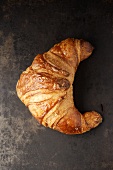 Ein Croissant auf dunklem Untergrund