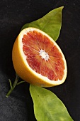 Half a blood orange ('Tarocco' variety) with leaves